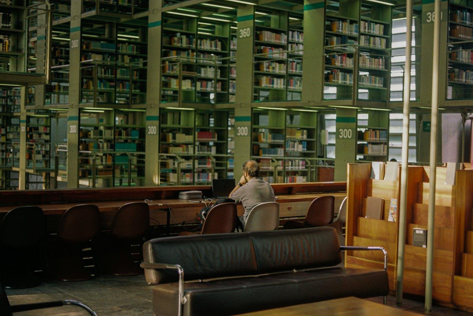 A student reading at a table in a library